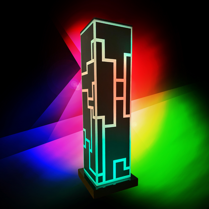 A sleek, modern table lamp called Lumishine CyberTower™ with a black acrylic body featuring futuristic geometric patterns. The lamp emits vibrant RGB lighting, creating a colorful and ambient glow. The background displays a gradient of bright colors, enhancing the lamp's visual appeal. The Lumishine logo, in a multicolored font, is prominently displayed to the left of the lamp. This lamp combines advanced lighting technology with a stylish design, perfect for any contemporary living space.